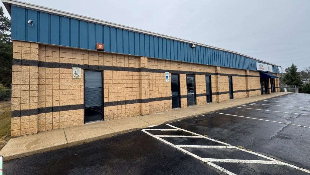 Storefront entrance with dark blue awning and glass windows on a commercial building facade