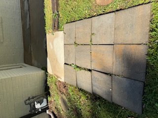 Same wall with clean siding, crisp window, and tidier utility fixtures after washing.
