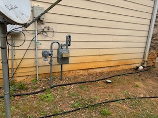 Concrete driveway with damp-looking stains and uneven tone before cleaning.