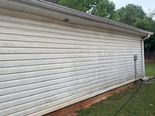 Concrete retaining wall and sidewalk with weathered surfaces before cleaning.