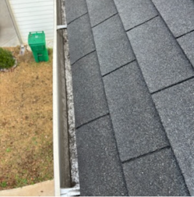 Same gutter line cleared of heavy debris with shingle granule buildup visible for comparison